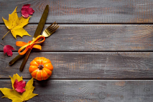 istock Thanksgiving table setting with cutlery pumpkins and autumn leaves 1290300831