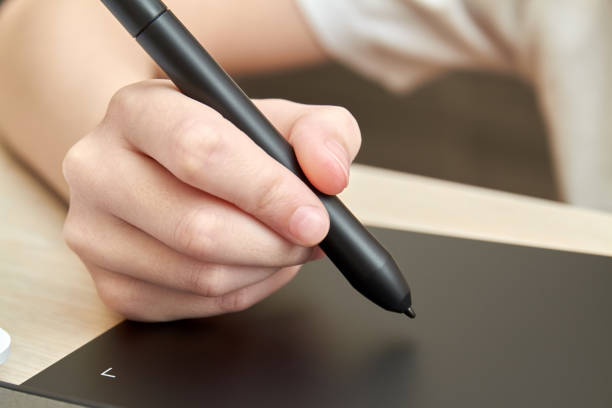 istock Girl draws on a graphics tablet with pen. Close-up, selective focus 1290308860