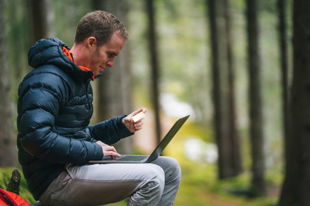 istock Young man works remotely in lush forest in the morning 1290309103
