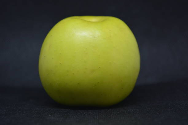 pomme verte juteuse mûre, le fruit frais est situé sur un fond noir de tissu. - dried fruit variation healthy eating snack photos et images de collection