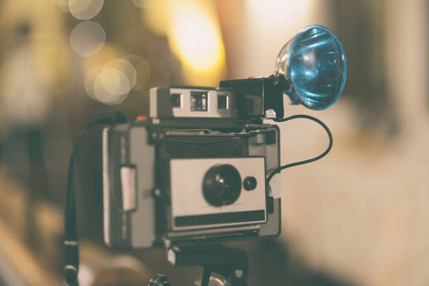istock Retro photo camera with tripod and flash at night event with a very vintage image 1290309204