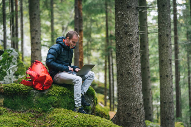 istock Young man works remotely in lush forest in the morning 1290309247