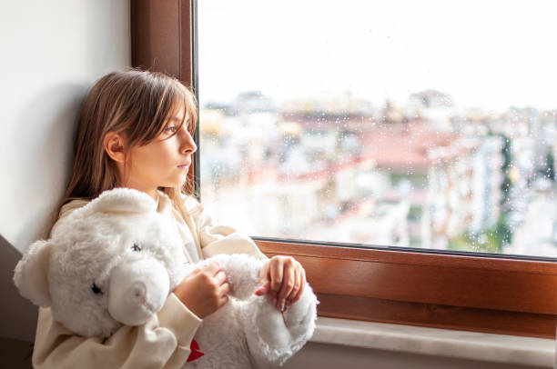 istock Cute girl boring at home with her teddy bear 1290309544