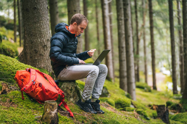 istock Young man works remotely in lush forest in the morning 1290309574