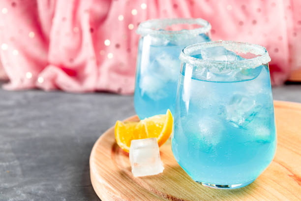 istock Cocktail with ice and blue curacao on a delicate pink background 1290311627