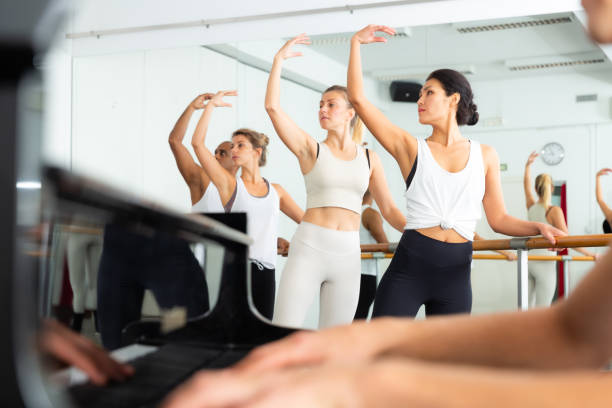 istock Multiethnic dancers training with one hand on barre under live music 1290312511