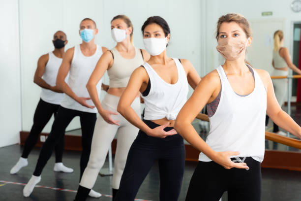 istock Ballet troupe in protective masks rehearses in ballet class 1290312539