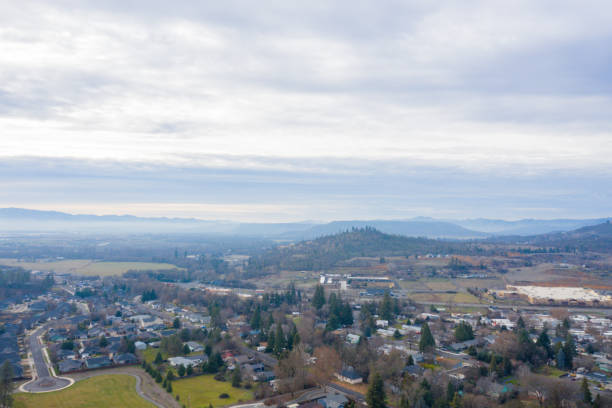 istock Peaceful town surrounded by trees with mountains as background 1290314417