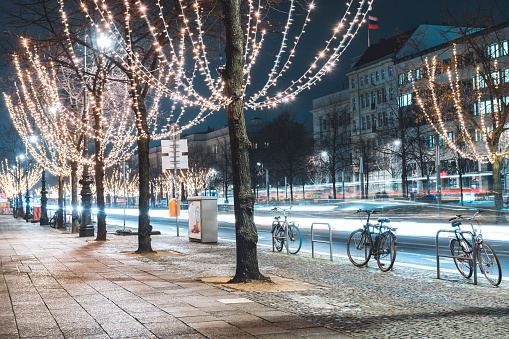 festive illuminated trees in shopping street unter den Linden in Berlin at blue hour in december