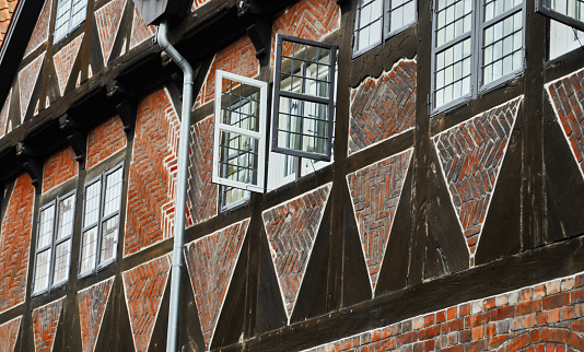 Brick masonry filled infill in a half-timbered house in the historic old town of the Hanseatic city of LÃ¼neburg with an open window on the upper floor