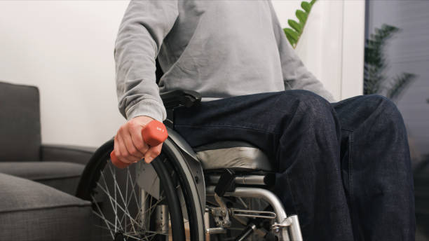 istock Man in wheelchair exercising 1290320238