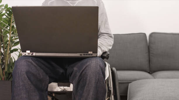 istock Young man in wheelchair with laptop 1290320298