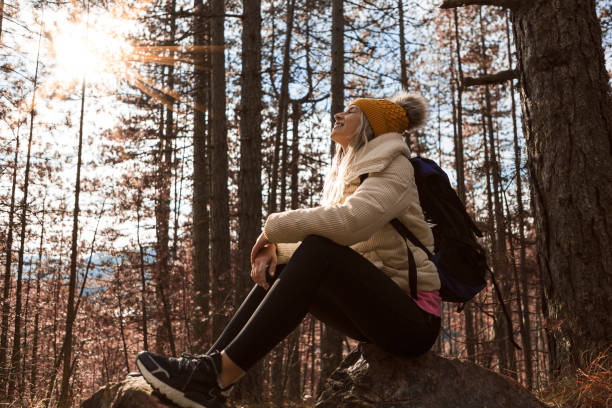 istock Young woman in woods hiking alone ,taking a break 1290320375