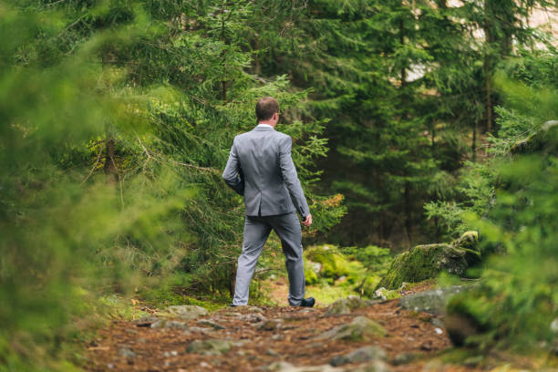 istock Business man walks through lush forest in the morning 1290320380