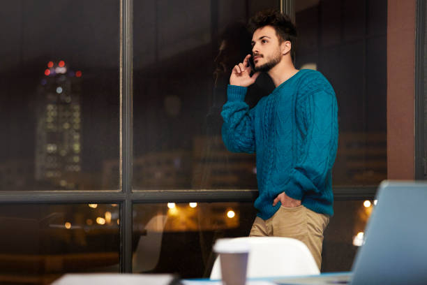 istock Businessman Working Late and Talking on Mobile Phone in Office 1290321007