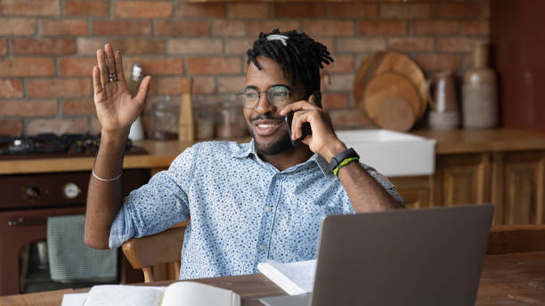 istock Smiling biracial guy in eyeglasses involved in funny cellphone talk. 1290323437