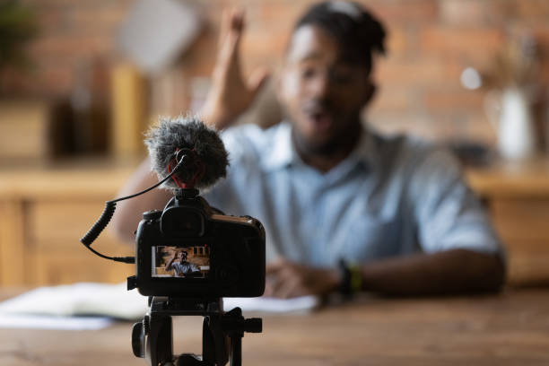 istock Close up focus on photo camera with microphone recording video. 1290323438