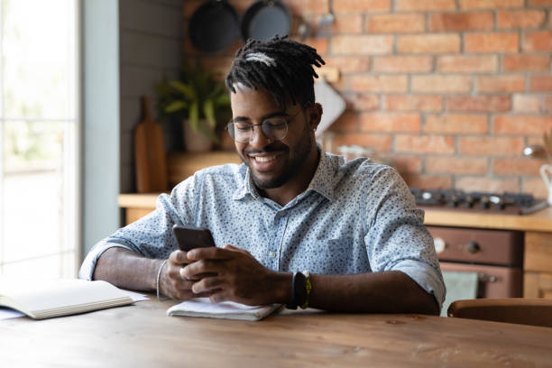 istock Smiling young african american man using mobile phone. 1290323440