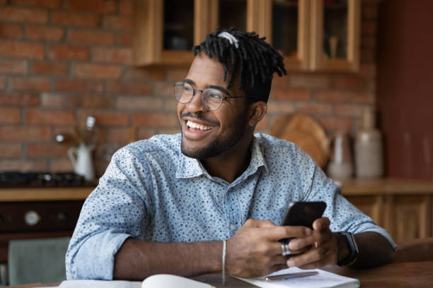 istock Happy young african ethnicity man using smartphone. 1290323442