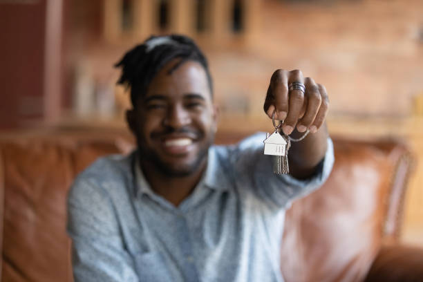 istock Close up focus on keys in smiling african guy hands. 1290323468