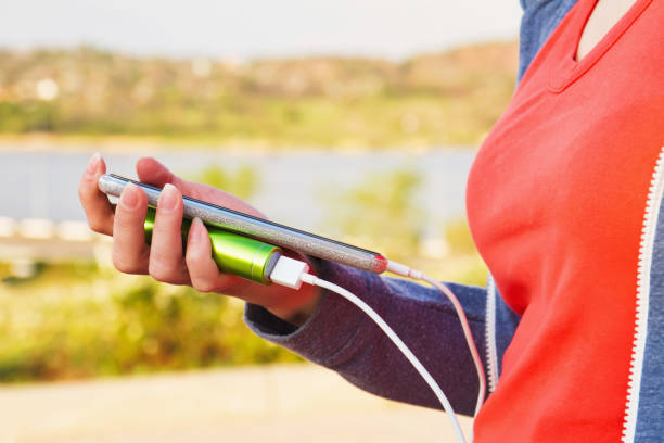 istock A girl uses a smartphone outdoors while charging from an external power bank 1290325124