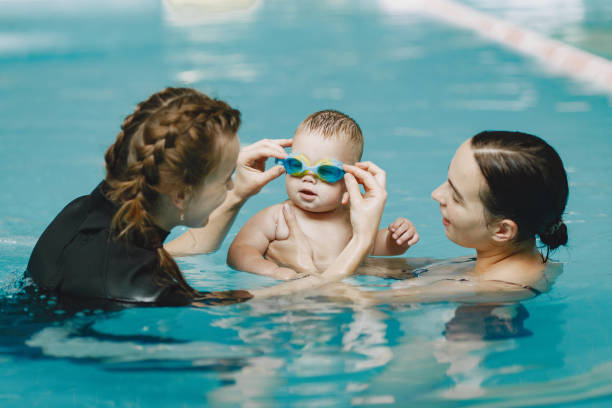 istock Mother and little son in a swimming pool 1290326258