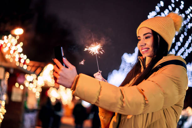 istock woman uses a cell phone at a Christmas bazaar 1290329207