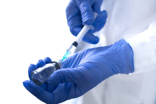 istock Hand holding syringe and vaccine. 1290330151