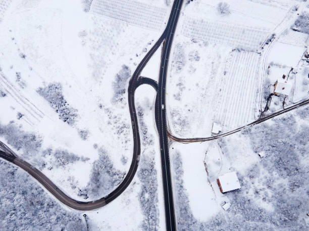 High angle top down aerial view drone image on road trough the trees and forest in mountain range covered with white snow in winter day near Knjazevac in Serbia - Travel journey and vacation concept alto ángulo de arriba hacia abajo vista aérea imagen del dron en la carretera a través de los árboles y el bosque en la cordillera cubierta de nieve blanca en el día de invierno cerca de knjazevac en serbia - viaje de viaje y concepto de vacaciones