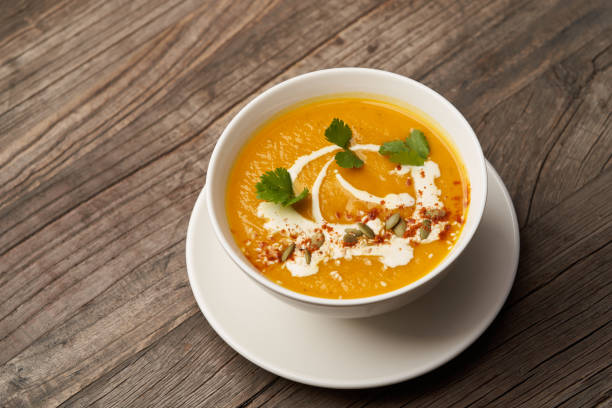 istock Pumpkin soup on a wooden table. Pumpkin soup puree 1290332810