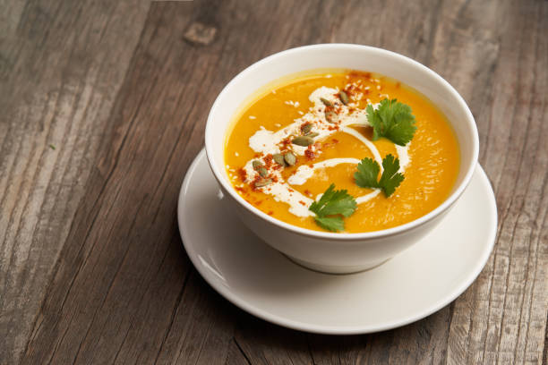 istock Pumpkin soup on a wooden table. Pumpkin soup puree 1290332816