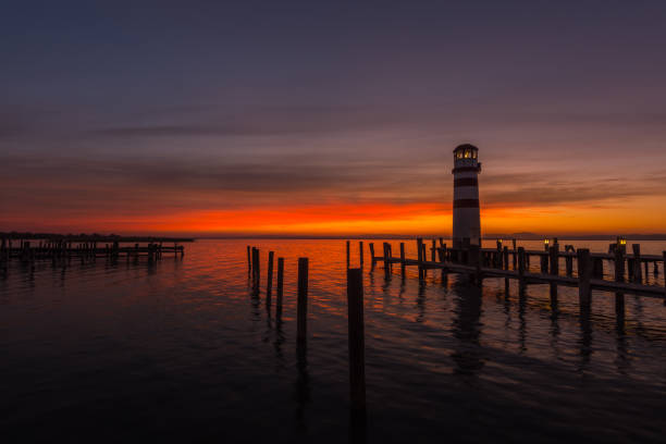 istock sunset with clouds at the lake with little lighthouse 1290333103