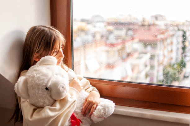 istock Cute girl boring at home with her teddy bear 1290335416