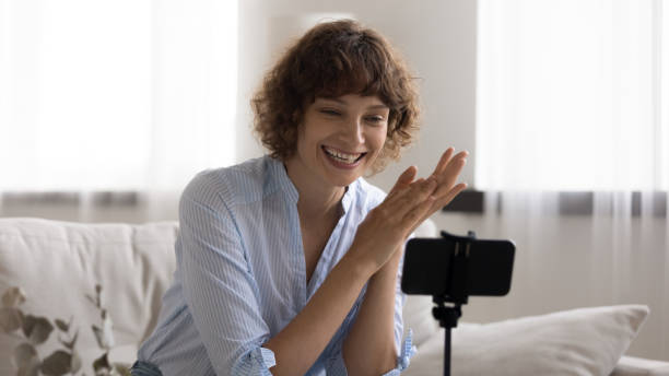 istock Close up overjoyed young woman recording video, using phone 1290335569