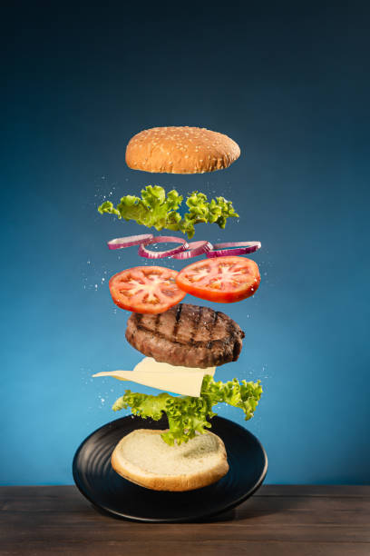 istock Flying burger on  wooden base and blue background. 1290335918