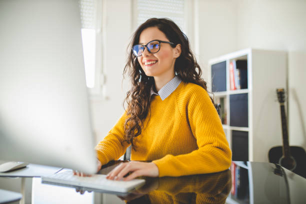 istock Portrait of young woman using computer and working at home 1290338417