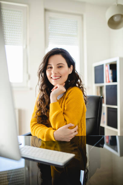 istock Portrait of young woman using computer and working at home 1290338815