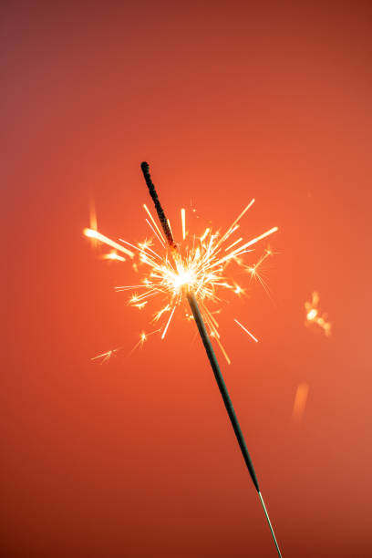 istock A burning sparkler on a colorful background 1290338846