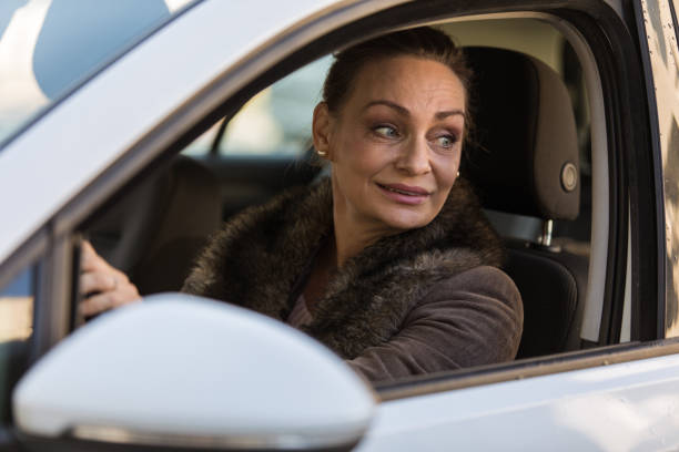 istock Mature woman driving her car in reverse 1290338928