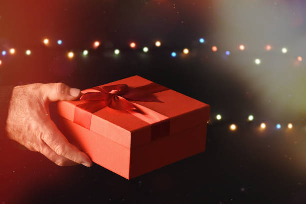 istock Men's hand holding a red gift box 1290341342