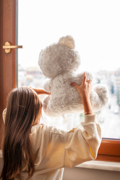 istock Cute girl boring at home with her teddy bear 1290341648