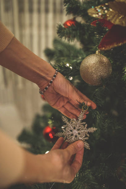 istock Hanging a snowflake ornament on a Christmas tree 1290343070