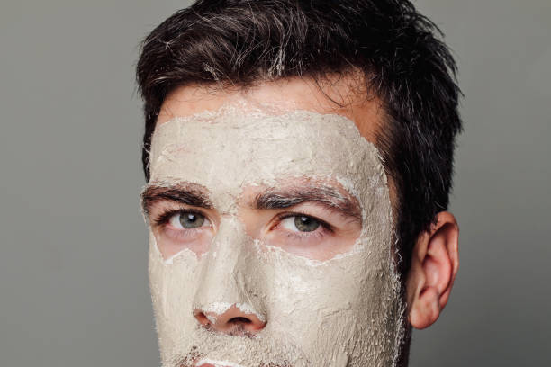 istock Male Skincare: Handsome Caucasian Man with a White Face Mask 1290344119
