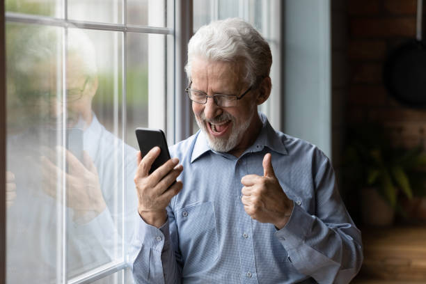 istock Close up overjoyed mature man using phone, reading good news 1290347087