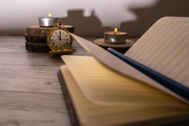 istock selective focus of an antique clock and a notebook hoping to get ideas for writing down 1290350411