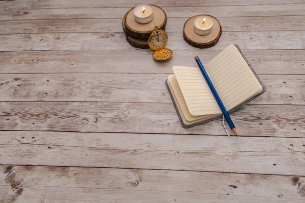 istock notebook looking for ideas along with lit candles and antique clock with copy space 1290350418