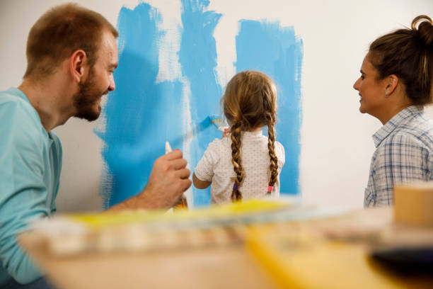 istock Parents painting the wall with their toddler assisting them 1290350840
