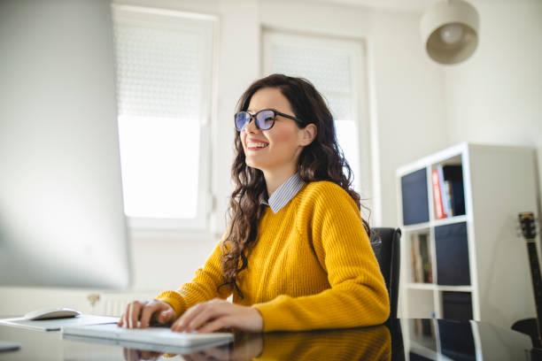 istock Portrait of young woman using computer and working at home 1290351525