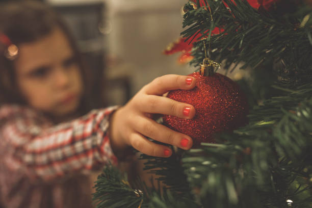 istock Hanging a sparkly ornament on a Christmas tree 1290355138