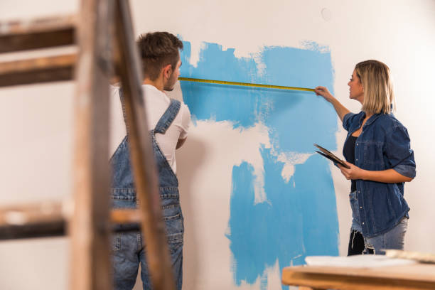 istock Couple taking measurements of a wall while renovating 1290356850